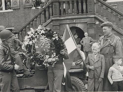 zwartwitfoto van soldaten en burgers voor het Stadhuis