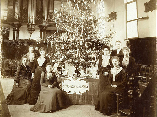 oude foto van dames bij een kerstboom met verlichting