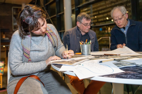 mensen aan een tafel met informatiefolders - fotografie Vincent van Dordrecht