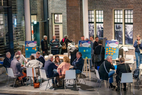 overzichtsbeeld van de ruimte met bezoekers aan tafels - fotografie Vincent van Dordrecht